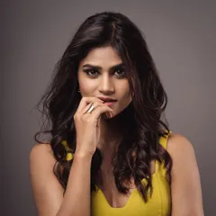 A confident and stylish portrait of a model in a vibrant yellow top. Her engaging expression and relaxed pose make this a versatile shot for a professional portfolio.
