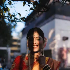 The play of light and shadow adds a beautiful, artistic touch to this bridal portrait. The bride's serene smile is captured perfectly as the sun peeks through the leaves.