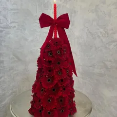 Chic, glorious, and festive. This unique Christmas tree is made entirely of fresh red gerbera daisies, complete with a matching red candle on top. It's a modern and floral take on a holiday classic.