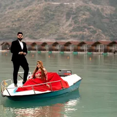 A beautiful pre-wedding portrait on a boat in Tehri Lake. The serene water and the backdrop of floating cottages create a unique and picturesque setting for a romantic photoshoot.
