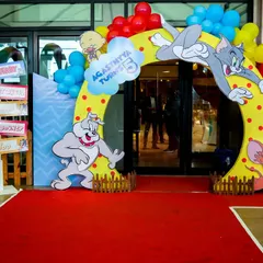 The party starts at the entrance. We create grand, immersive entryways like this Tom & Jerry arch, complete with a red carpet, that make guests feel like they're stepping right into the cartoon.