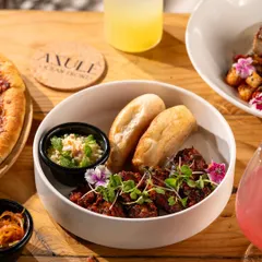 A small plate of Goan sausage chili with poi bread. A perfect appetizer shot that highlights a local specialty.