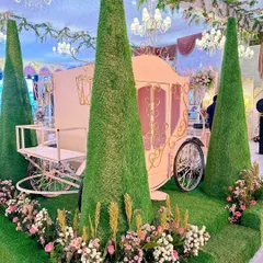 A closer look at the craftsmanship of our fairytale carriage. The elegant pink and gold details, combined with the surrounding floral arrangements and manicured greenery, create a truly enchanting focal point for any celebration.