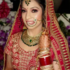 A classic getting-ready shot. This close-up captures the bride's flawless makeup, her beautiful smile, and the details of her nath and wedding jewelry.