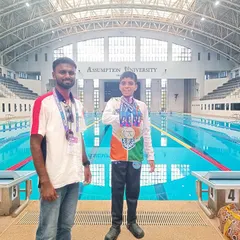A champion and his mentor. Bryce Leyton stands with his coach after a successful day at the Asian Open Schools Invitational Swimming Championship in Thailand. This photo represents the crucial partnership between swimmer and coach that is essential for achieving success at the highest levels.