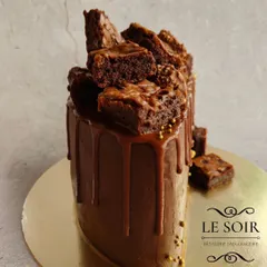 This semi-circle cake is a chocolate explosion. It's a 1 kg Ferrero Crunch cake with a ganache finish, Nutella drip, and a generous pile of my homemade Nutella brownies on top.