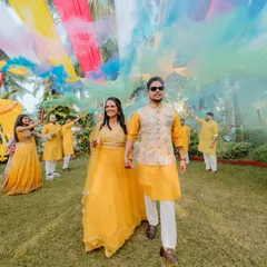 The couple makes a grand entrance at their Haldi ceremony, walking through a cloud of coloured smoke. The colourful fabric canopy above them adds to the festive and high-energy moment we aimed to create.