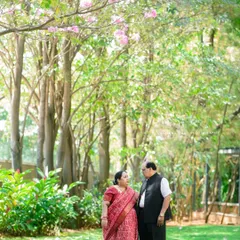 An anniversary portrait of a couple in a beautiful park, under blooming trees. Outdoor anniversary photoshoots are a wonderful way to celebrate your journey together.