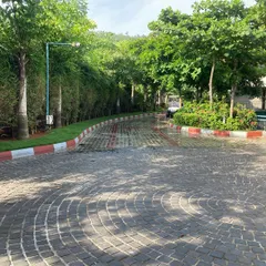 This project involved laying a fan-patterned cobblestone driveway, bordered by a crisp red and white curb. The surrounding greenery and bamboo hedge create a private and polished look for the property.