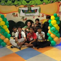 A group of boys gathers for a photo in front of our Tingaland sign, surrounded by festive balloons.