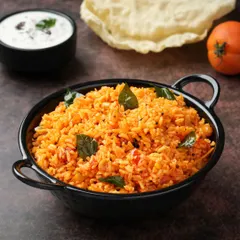 The rich color of this Tomato Rice is its main appeal. We used dark, moody lighting to make the colors pop and highlight the fresh curry leaves, making a simple dish look exceptionally flavorful.