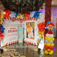 Another view of the carnival party photo corner, showcasing the vibrant red, blue, and yellow balloon columns and clown prop.