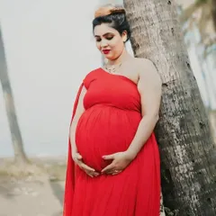 A peaceful portrait of a mom-to-be. The one-shoulder design of this red georgette gown is both stylish and comfortable for a maternity session.