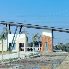 The main gate of the Kanpur row housing project, post-construction. This image shows the successful translation of our design render into a physical structure, featuring a mix of wood-textured panels and angled steel supports.