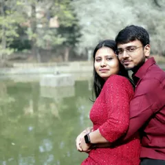 A warm and intimate portrait of the couple hugging by the lake. This close-up shot focuses on their happy expressions and the beautiful natural lighting of the park.