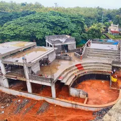 The TAPMI Centre under construction, showing the concrete shell of the stepped amphitheater before the installation of the parasols. This view reveals the project's complex levels and inward-looking design.