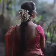 The back view of a bride, highlighting the beautiful gajra (floral arrangement) in her hair, a signature element of the South Indian bridal look.