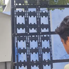 A team member installs the interlocking modular panels onto the MS frame. These panels are the backbone of the green wall, holding the soil and plants in place.
