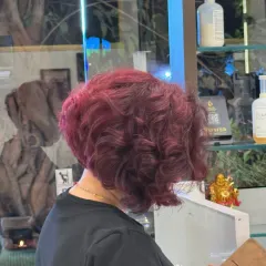 This side view captures the beautiful, rich tones of a warm wine hair color. Paired with a fresh bob, it's a look that exudes confidence and modern elegance.