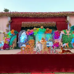 I can transform any large outdoor space, like this farmhouse lawn, into a vibrant jungle. This setup features a massive stage with life-sized animal props like elephants and giraffes, themed backdrops, and colorful balloon arrangements to create an immersive safari experience for a child's birthday.