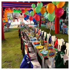 The kids' dining area is ready for heroes! Each chair is adorned with a superhero cape, and the table is set with comic-book "POP!" signs and themed tableware.