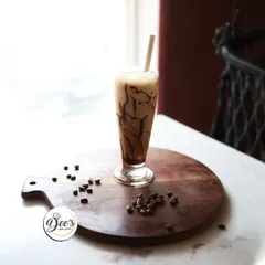 A refreshing glass of our signature cold coffee, perfectly framed by the window light in our cozy cafe.