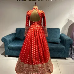 The back of a royal red Anarkali gown made from Banarasi fabric, featuring a stylish keyhole back.