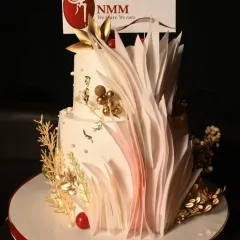 A two-tier corporate cake I was honored to bake for the Navi Mumbai Moms group. The design features elegant wafer paper decorations, gold accents, and the group's logo.