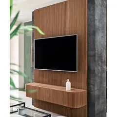 This floating TV unit is a statement piece, crafted with a wooden fluted panel that curves at the bottom. Set against a dark, textured wall, it creates a sophisticated and modern focal point in the living area.