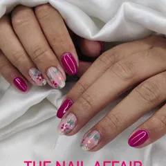 A beautiful floral design with delicate white and pink flowers on a sheer nude base, paired with solid magenta accent nails.