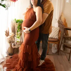 A beautiful couple pose in our warm, rustic boho setting. The earthy tones of the gown and decor create a cohesive and natural look for this lifestyle maternity portrait.