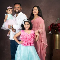 A picture perfect family portrait. Everyone is looking at the camera, beautifully posed against a classic, formal backdrop. It's a timeless keepsake for any family.