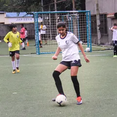This player demonstrates excellent ball control and focus during a training session, showcasing the talent within our girls' teams.