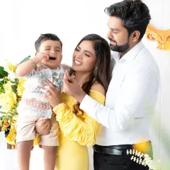 A candid and playful family moment. The parents share a laugh while their toddler makes a funny face, showing the real and unscripted joy that makes family photos so special.