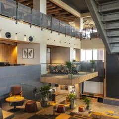 The open-plan layout at Primarc features floating meeting rooms and breakout zones that overlook the central atrium. This design maintains a sense of openness and continuity, allowing energy and light to flow freely throughout the office.