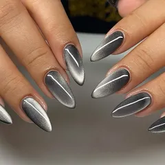 Dripping in metallic magic. This silver cat-eye set on long stiletto nails is sleek, futuristic, and guaranteed to turn heads. The sharp line of light creates a beautiful, elongating effect.