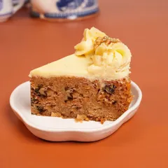A perfect slice of my Carrot Walnut Tea Cake. This winter favorite is full of warm spices, freshly grated carrots, and crunchy walnuts, all topped with a delicious cream cheese frosting.
