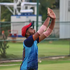 A fielder positions himself perfectly for a high catch near the boundary. This requires timing, judgment, and confidence, all of which we build through practice.