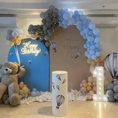 Another view of the stylish hot air balloon theme, showing the large teddy bear prop and the cloud-like effect of balloons at the base of the backdrop.