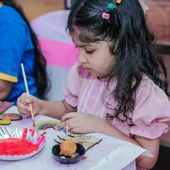 A young girl carefully painting a wooden magnet at Freya's Wonderland party. I offer a variety of shapes and colors to spark every child's imagination.