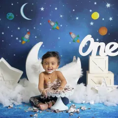 The aftermath of a successful cake smash. This little astronaut is covered in chocolate cake, sitting proudly in his outer space themed set. These are the messy memories you'll love.