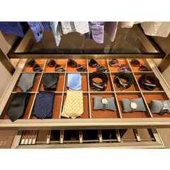 A pull-out drawer with custom, leather-lined compartments for a gentleman's accessories. Watches, sunglasses, and ties each have a designated spot, making the morning routine seamless.