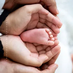 A newborn's foot held safely and lovingly in the hands of their parents. These detail-oriented shots are a beautiful way to remember just how small they once were.