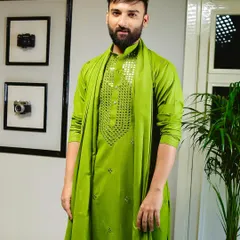 Make a vibrant statement with this green kurta set. The chest is adorned with intricate hand-applied mirror work, adding a touch of festive sparkle to the rich color.