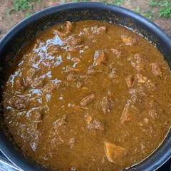 This is our Pandi Curry simmering on a slow flame. This gentle cooking method is key to developing a thick, coating curry and ensuring the pork becomes perfectly moist and infused with flavor.