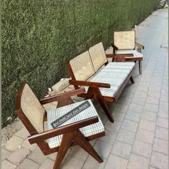 A closer look at the Pierre Jeanneret style lounge set, highlighting the distinctive V-shaped legs and the quality of the cane work.
