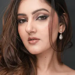 This direct-to-camera shot showcases the symmetry and precision of the winged liner. The makeup is blended to perfection, creating a flawless canvas that looks stunning in portraits.