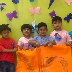 Learning our letters is fun! A group of proud students from our Mighty Minds program show off the giant letter 'N' they colored together, demonstrating teamwork and early literacy skills.