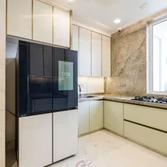 A closer look at the smart fridge and the custom cabinetry with soft gold trim. The design is a perfect example of muted modernism, where luxury is in the details.