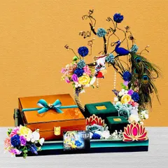 This Teej hamper is a work of art, featuring a decorative tree element and a peacock. The platter holds beautifully wrapped gift boxes, all brought together with a vibrant floral arrangement.